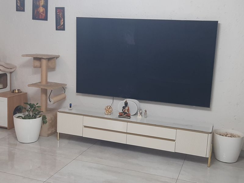 A living room area featuring large format porcelain floor tiles and dark venetian blinds, providing a neutral base for the space.