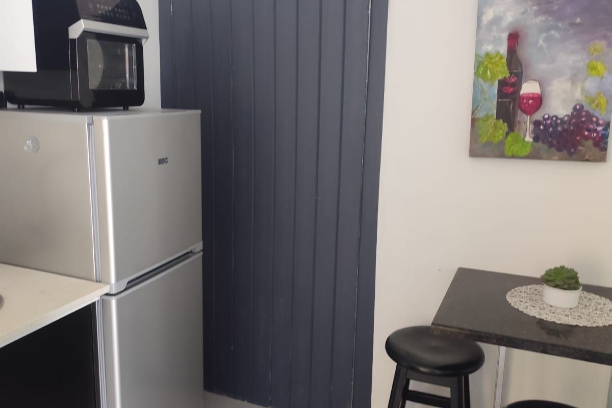 A compact kitchen area featuring modern cabinetry, tiled flooring, and a functional layout suitable for efficient meal preparation.