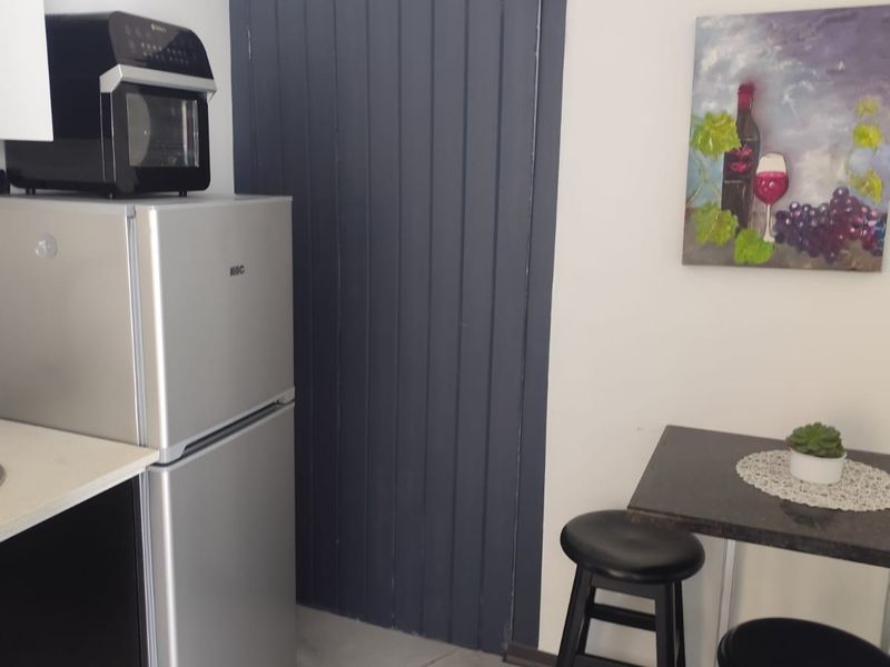 A compact kitchen area featuring modern cabinetry, tiled flooring, and a functional layout suitable for efficient meal preparation.