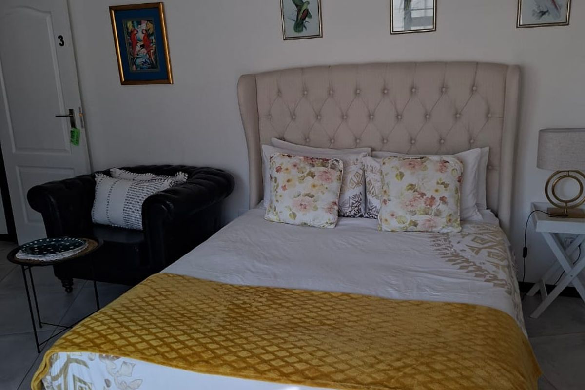 A well-maintained bedroom featuring neutral tiled flooring and recessed ceiling lighting, providing a clean and functional living space.