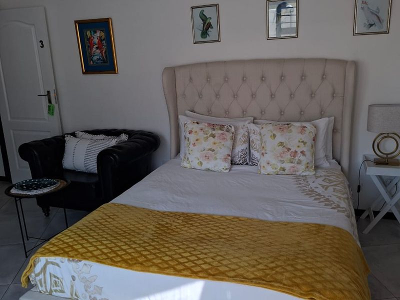 A well-maintained bedroom featuring neutral tiled flooring and recessed ceiling lighting, providing a clean and functional living space.