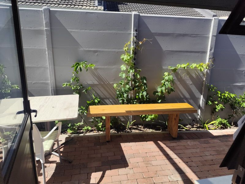 A private outdoor patio area featuring paved flooring and a secure precast concrete boundary wall, ideal for small-scale outdoor relaxation.