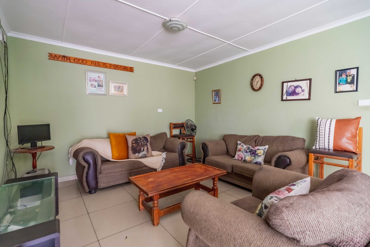 A comfortable living room featuring neutral tiled flooring and a standard ceiling, providing a functional space for relaxation.
