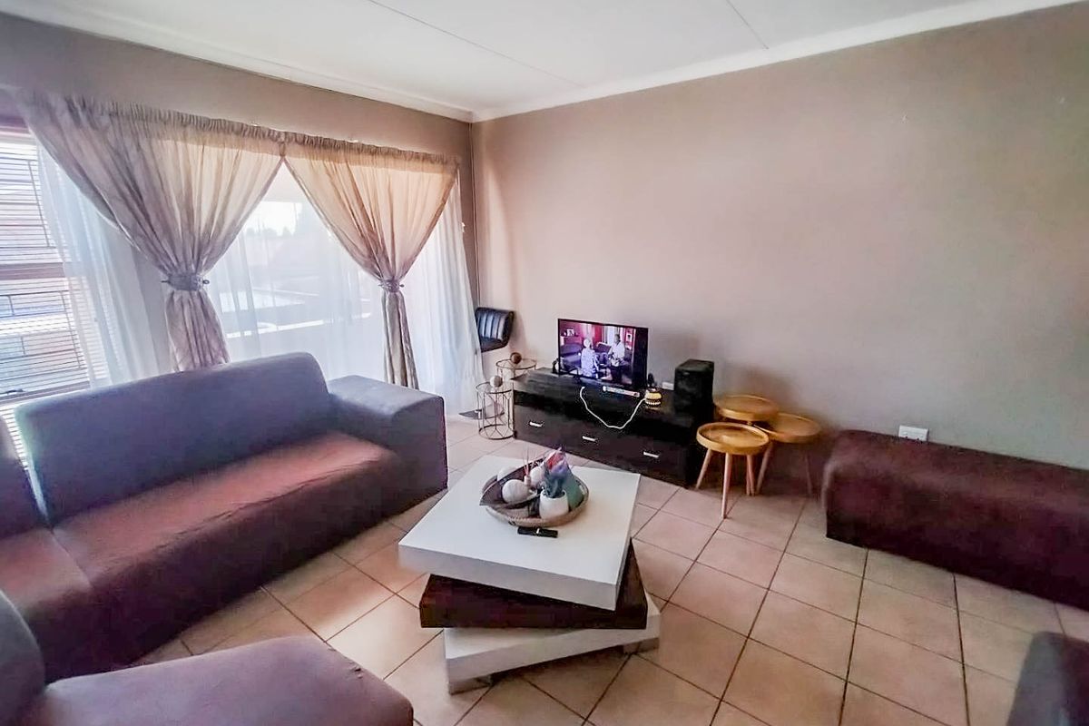 A living room featuring tiled flooring and neutral wall finishes, providing a functional and comfortable space for relaxation.