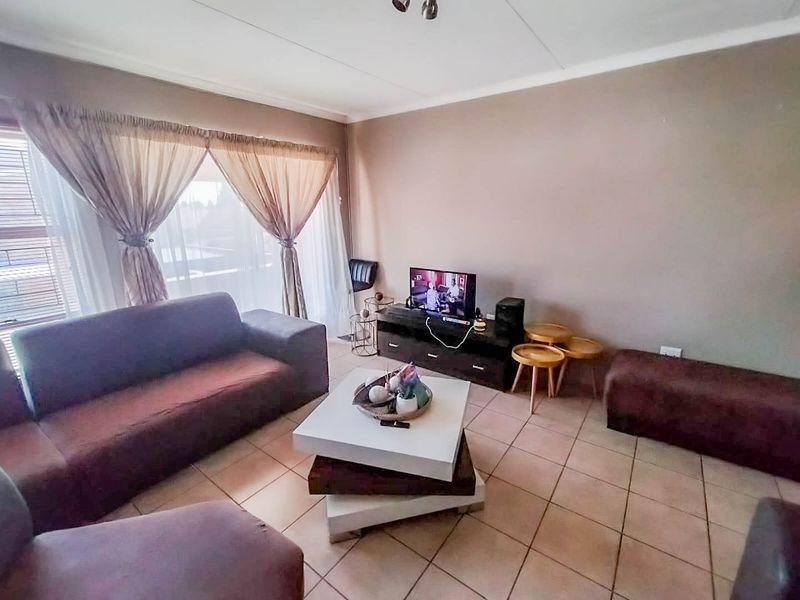 A living room featuring tiled flooring and neutral wall finishes, providing a functional and comfortable space for relaxation.