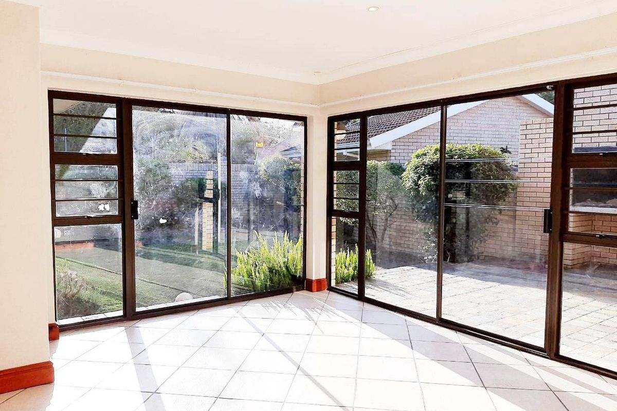 Bright and spacious living area featuring large sliding glass doors that provide seamless access to the outdoor patio and garden.