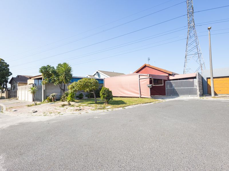 Front exterior view of the property featuring a driveway, gated entrance, carport, and garage, situated in a residential street setting.