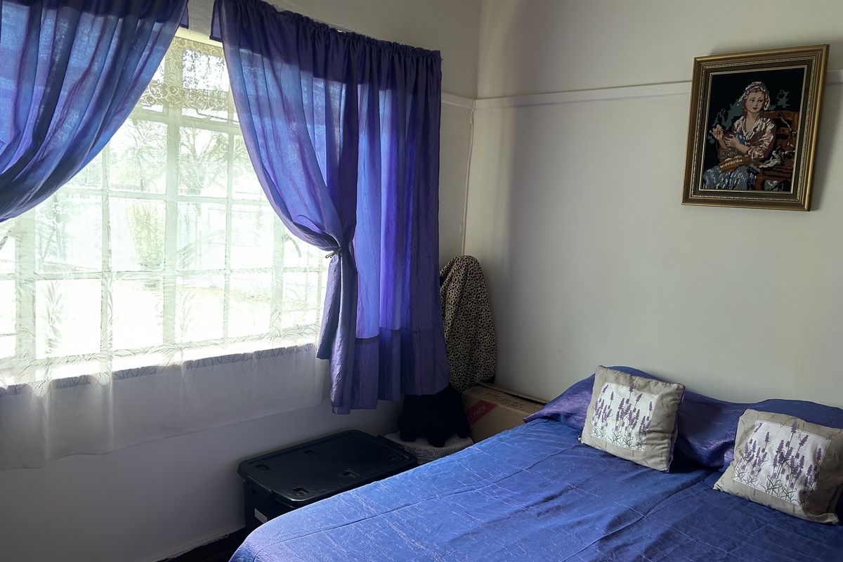 A bedroom featuring a multi-pane window with a picture rail, providing a functional space with natural light.