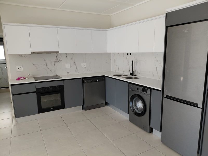 Modern kitchen featuring sleek two-tone cabinetry, marble-look splashback, integrated oven, hob, and extractor fan with tiled flooring.