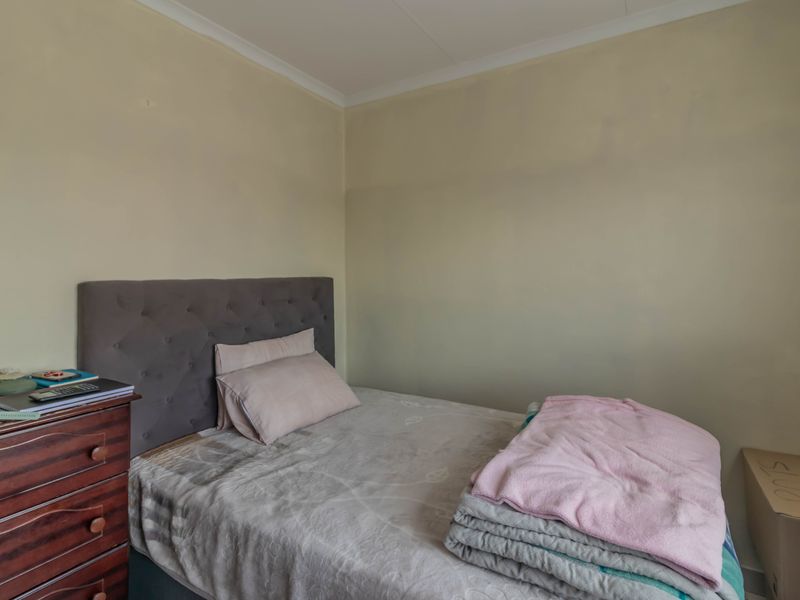 A compact bedroom featuring neutral wall tones, suitable for a single bed setup.