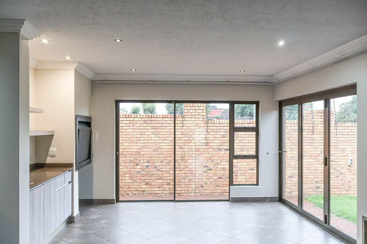 Spacious living area featuring tiled floors, recessed lighting, and large sliding glass doors providing direct access to the rear garden.