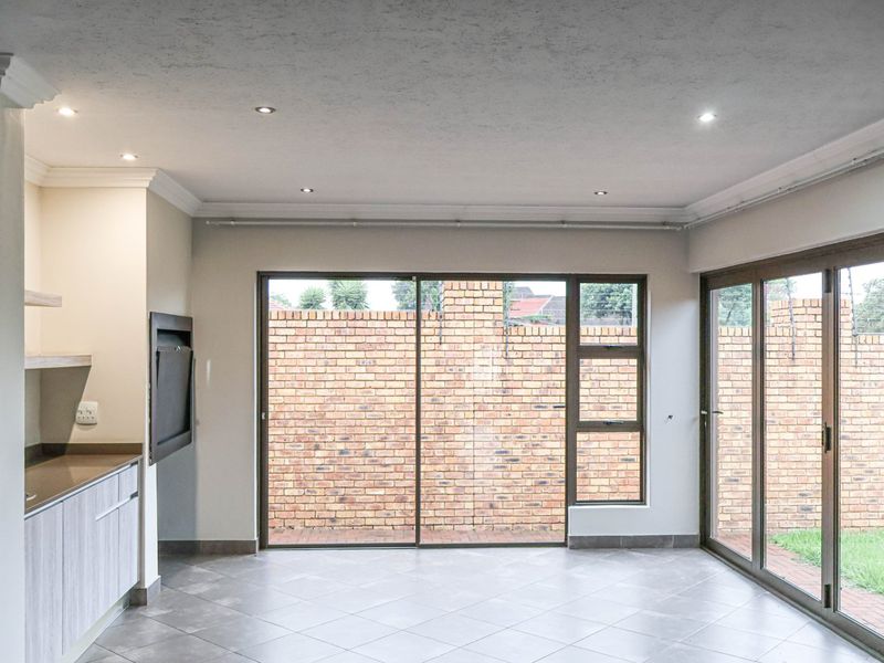 Spacious living area featuring tiled floors, recessed lighting, and large sliding glass doors providing direct access to the rear garden.