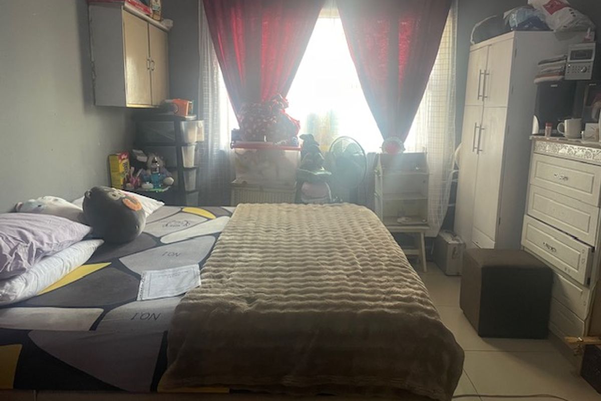 A bedroom featuring tiled flooring and a built-in wall cabinet, currently utilized as a sleeping space.