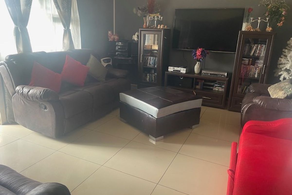 A comfortable living room featuring neutral tiled flooring and a functional layout, providing a solid foundation for modern interior updates.