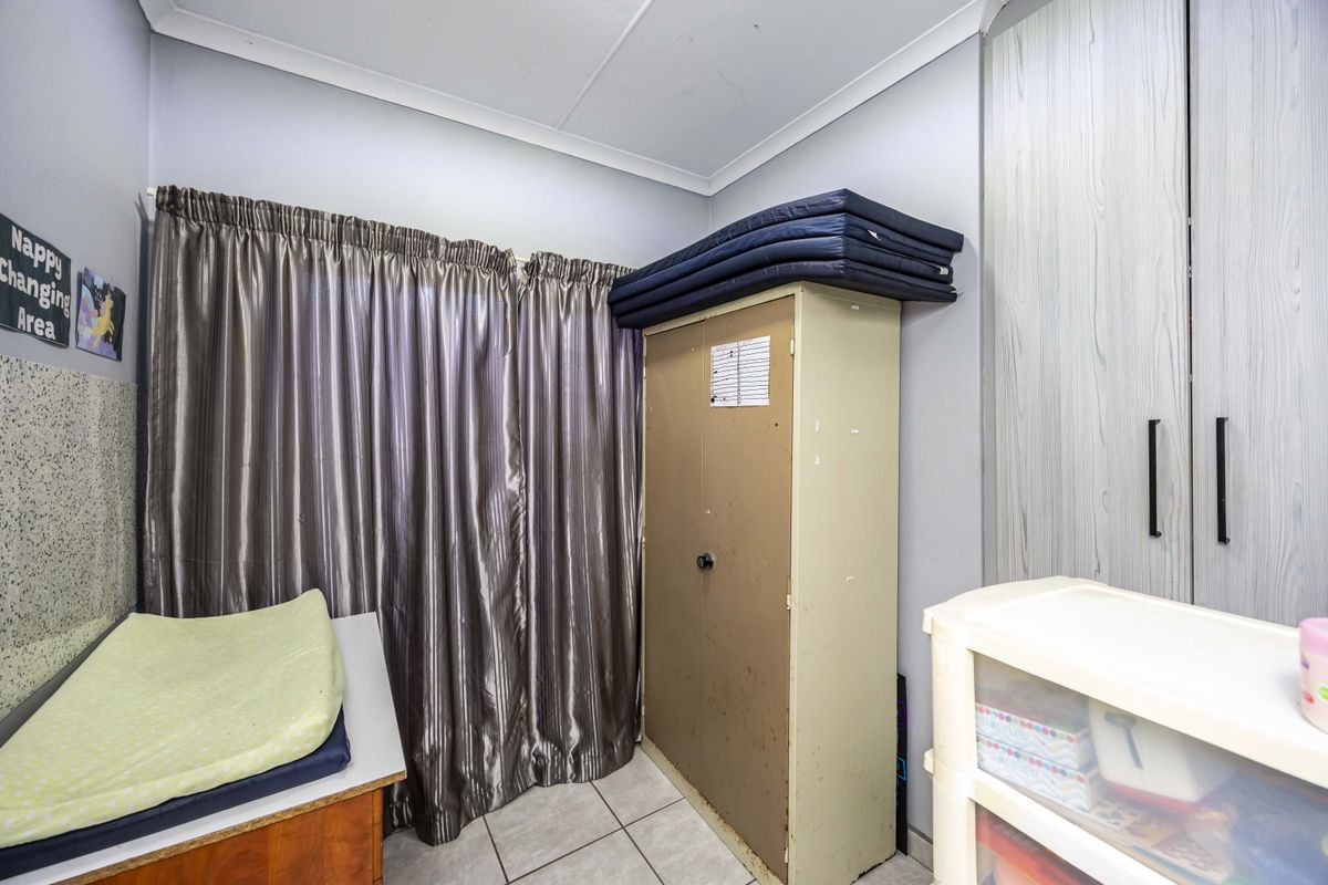 A bedroom featuring built-in cupboards, tiled flooring, and coved ceilings, offering a functional space ready for personalization.