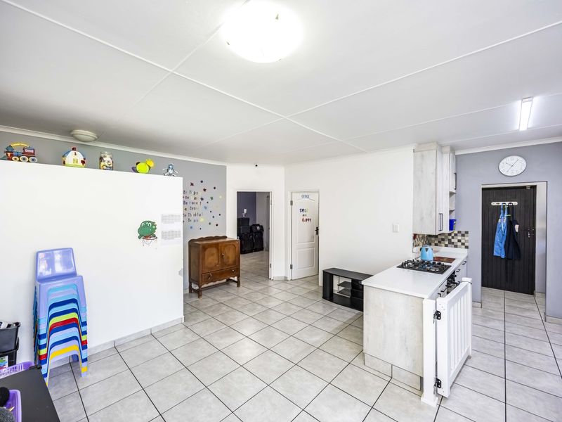 Open plan kitchen and living area featuring tiled flooring, built-in cabinetry, and a gas hob, offering a functional layout for daily living.