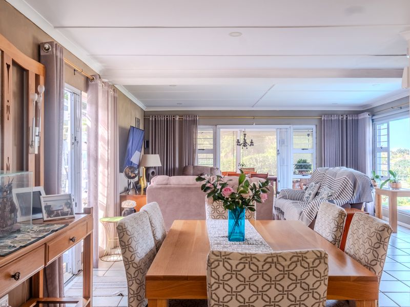 Spacious open-plan living and dining area featuring tiled flooring, abundant natural light through sliding glass doors, and neutral wall finishes.