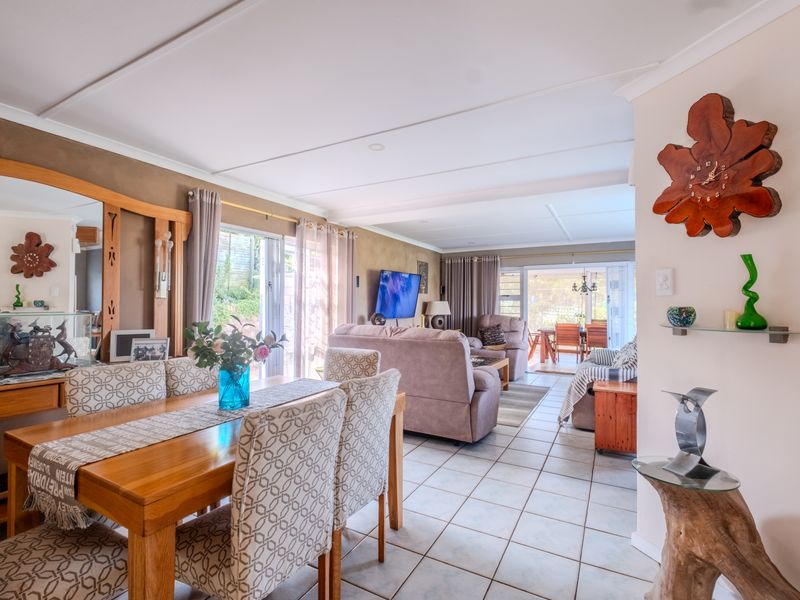 Spacious open-plan living and dining area featuring tiled flooring, neutral walls, and large sliding glass doors providing access to the outdoor patio.