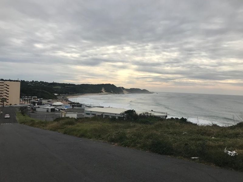A scenic coastal view overlooking the ocean, beach, and surrounding landscape from an elevated position.