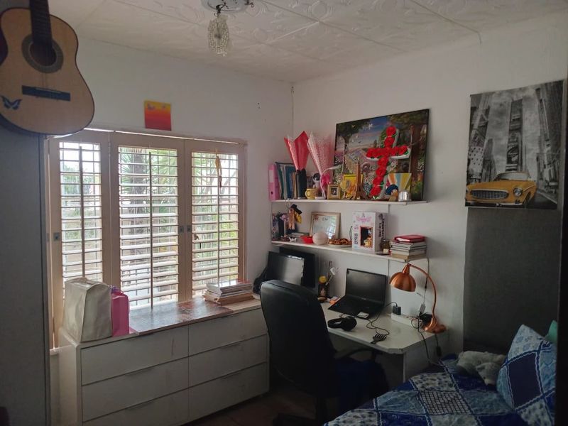 A bedroom featuring built-in shutters and wall-mounted shelving, providing a functional space with natural light.
