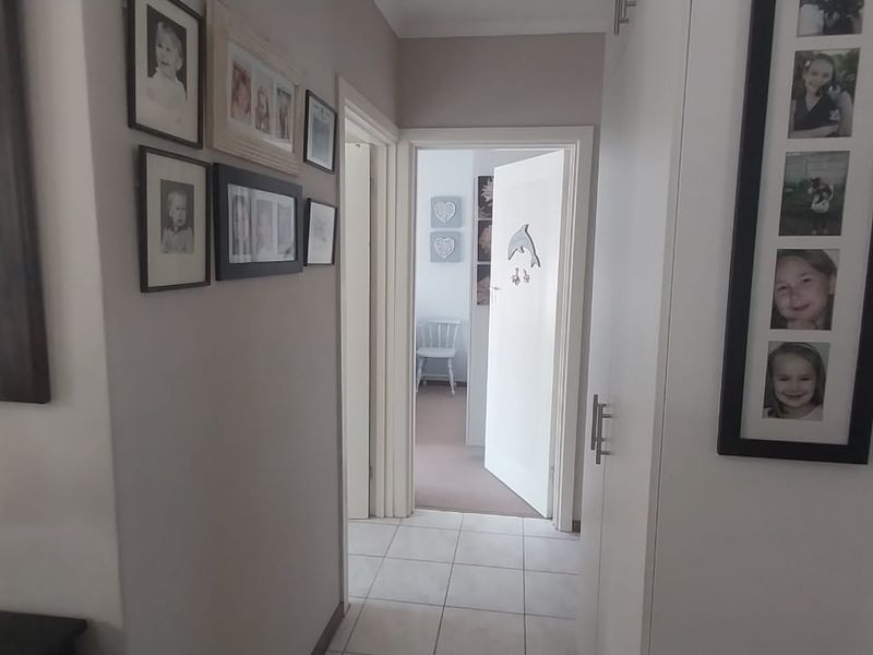 A functional hallway featuring tiled flooring and built-in storage, providing access to adjacent rooms within the townhouse.
