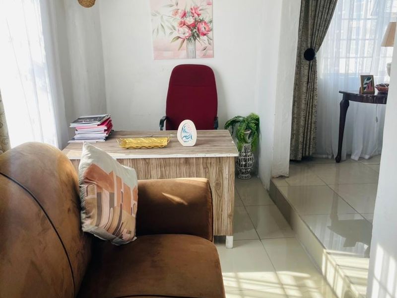 A functional home office space featuring tiled flooring and a raised floor transition, providing a distinct area for work or study.