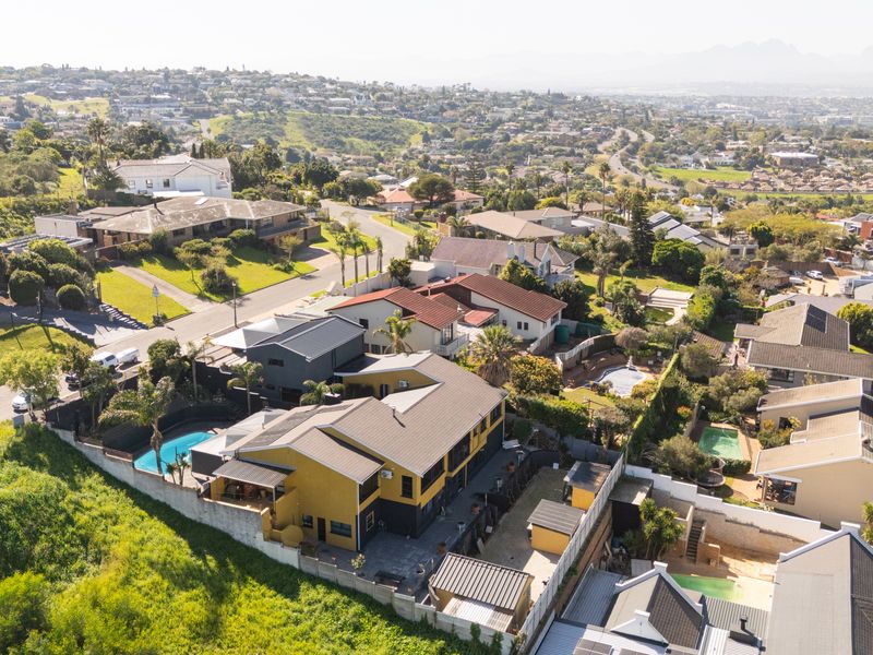 An aerial view of the property showcasing the house, swimming pool, and surrounding residential neighbourhood landscape.