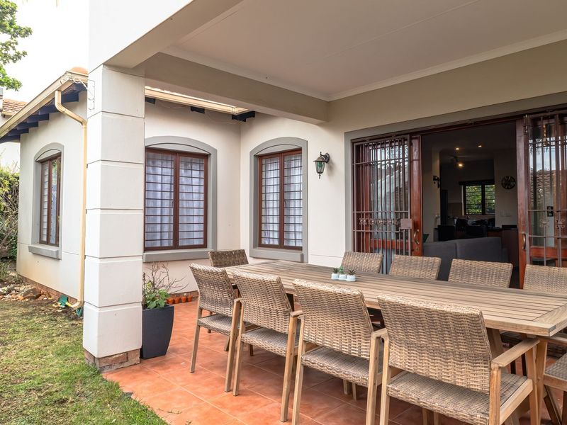 A covered outdoor patio area featuring tiled flooring and direct access to the interior through sliding security doors.