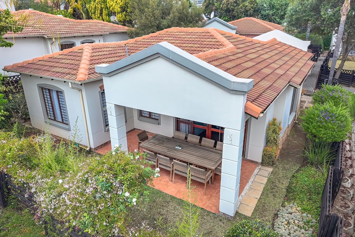 Aerial view of a residential property featuring a tiled roof and a covered patio area with terracotta flooring.