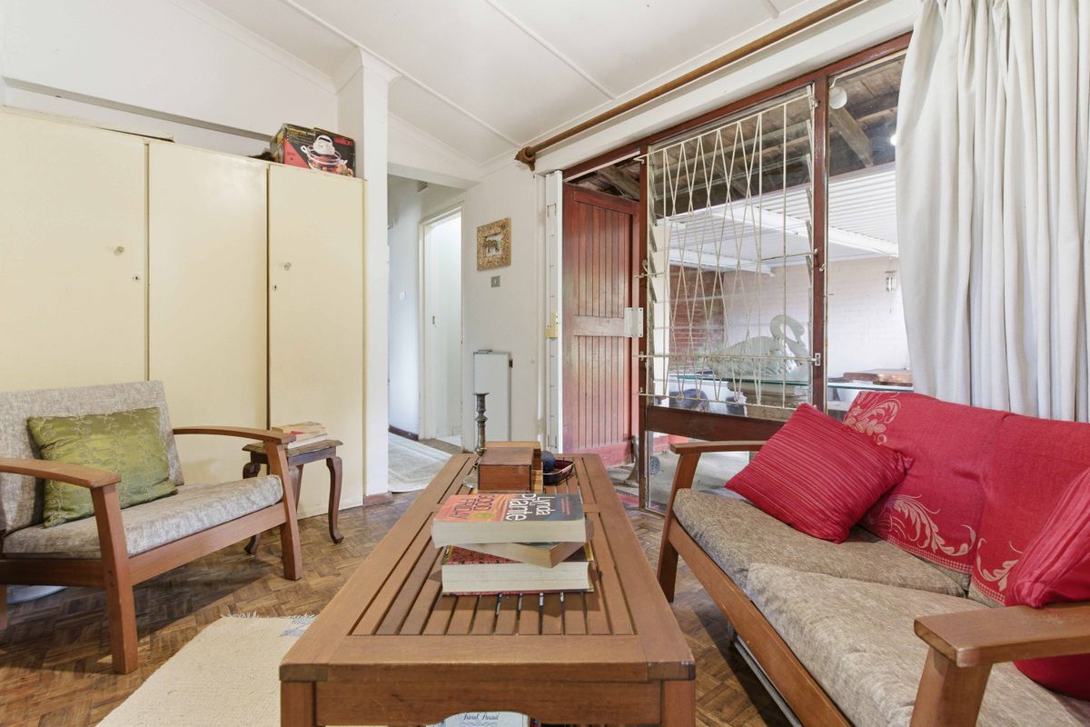 Living room featuring parquet flooring, built-in storage cupboards, and direct access to an outdoor area through a sliding glass door.