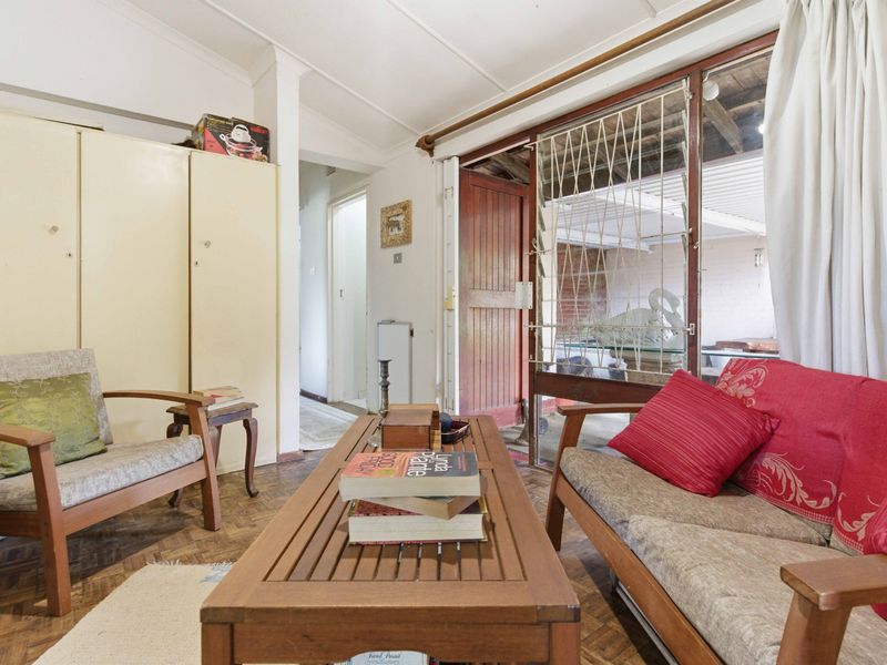 Living room featuring parquet flooring, built-in storage cupboards, and direct access to an outdoor area through a sliding glass door.