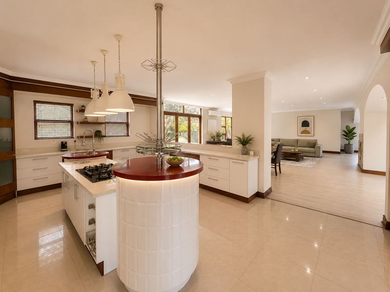 Spacious open-plan kitchen and living area featuring a central island with gas cooktop, modern cabinetry, stone countertops, and polished tile flooring.