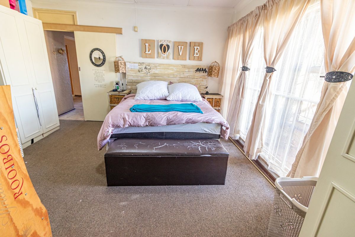 A bedroom featuring carpet flooring, a built-in wardrobe, and a sliding door providing access to the exterior.