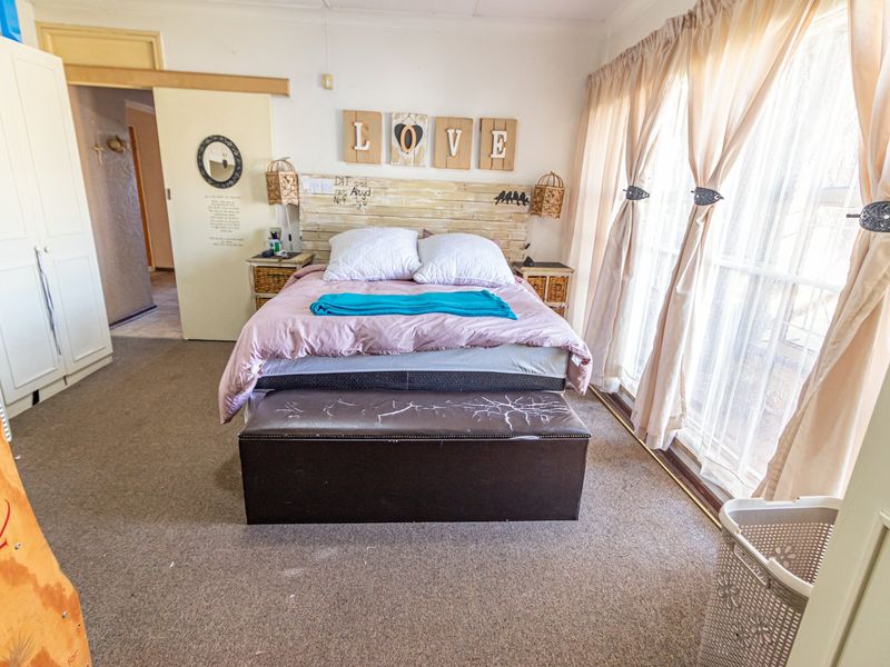 A bedroom featuring carpet flooring, a built-in wardrobe, and a sliding door providing access to the exterior.