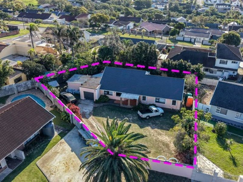 Aerial view of a residential property featuring a tiled roof, private swimming pool, and enclosed garden area within a suburban neighborhood.
