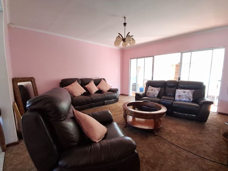 Spacious living room featuring carpeted flooring and large sliding glass doors that provide access to the outdoor area.
