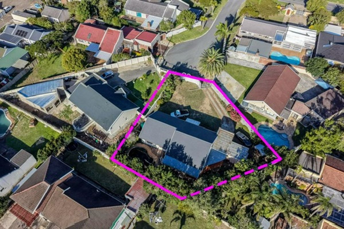 Aerial view of the residential property highlighting the roof structure, driveway, and surrounding garden area within the marked boundary.