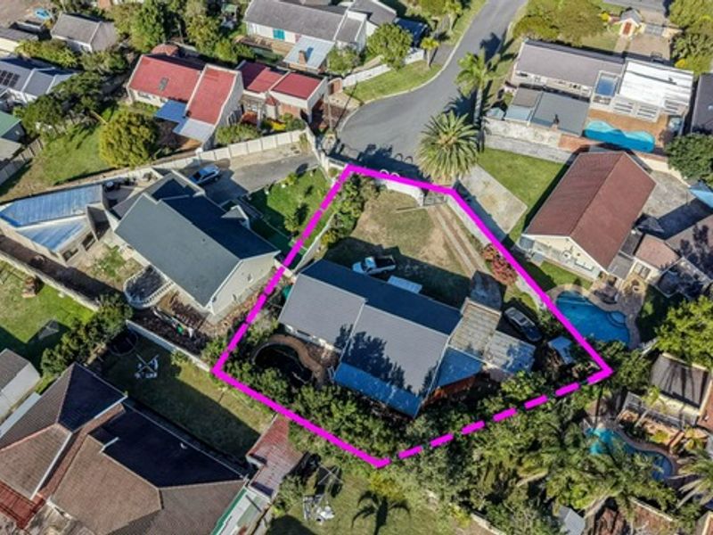 Aerial view of the residential property highlighting the roof structure, driveway, and surrounding garden area within the marked boundary.