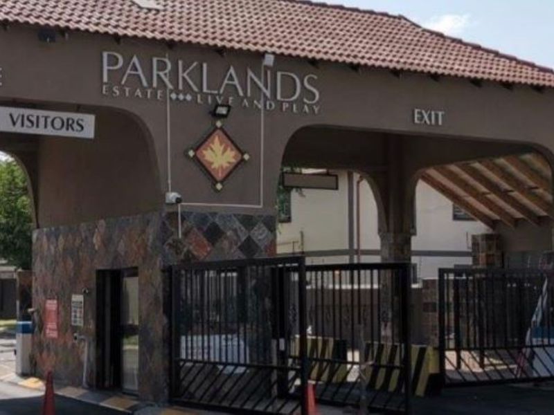 The main entrance and exit gatehouse of Parklands Estate, featuring stone cladding, tiled roofing, and integrated security infrastructure.