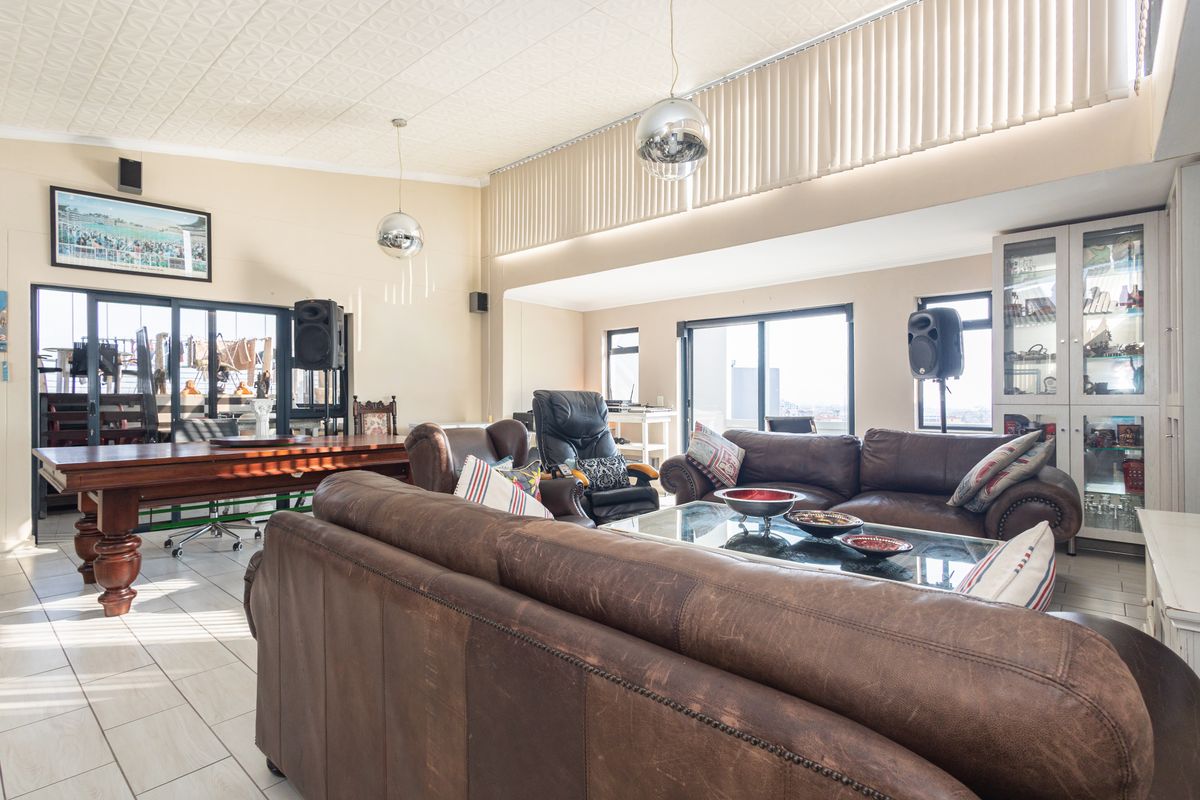 Spacious living area featuring tiled floors, large sliding glass doors providing natural light, and built-in display cabinetry.