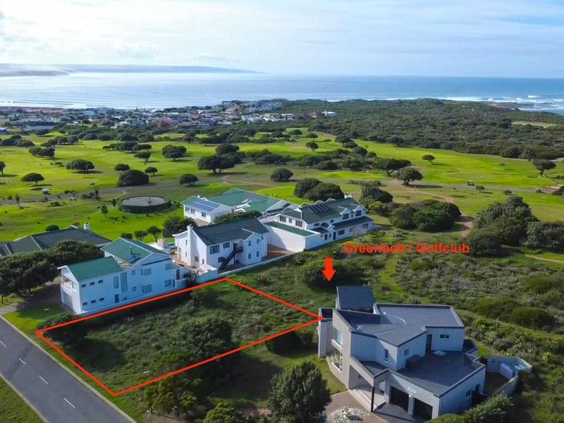 Aerial view of a vacant residential plot situated in a coastal estate, adjacent to a golf course and greenbelt area.