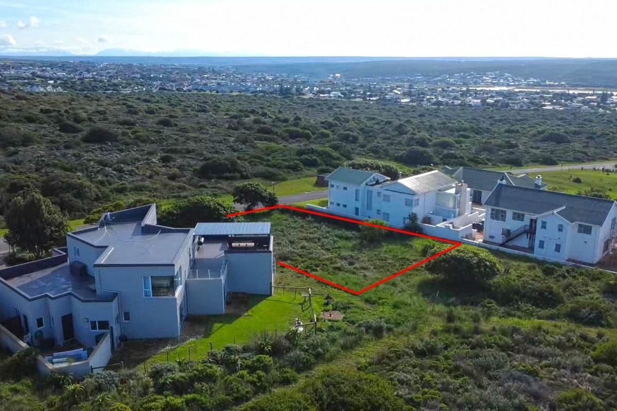 Aerial view of a vacant residential plot situated in a coastal neighborhood, highlighting the available land area and surrounding environment.