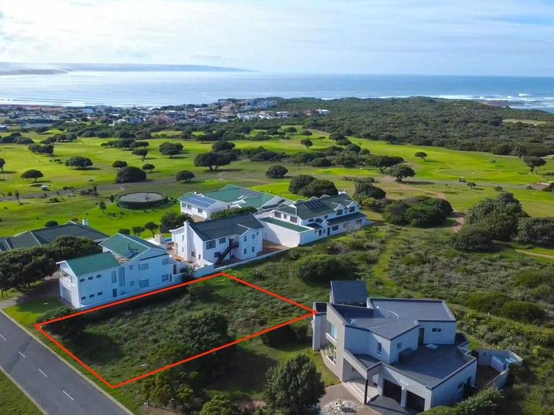Aerial view of a vacant residential plot situated in a coastal estate, adjacent to a golf course and established residential properties.