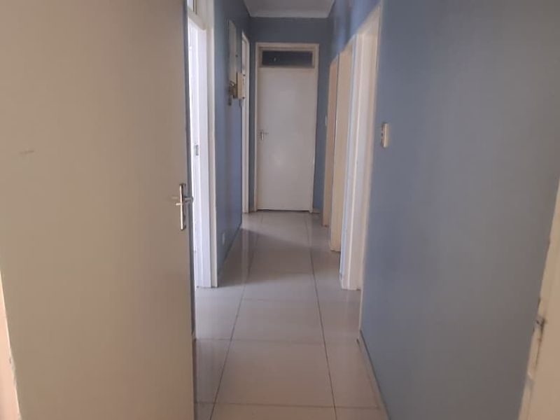 A functional hallway featuring tiled flooring and multiple internal doors, providing access to various rooms within the home.