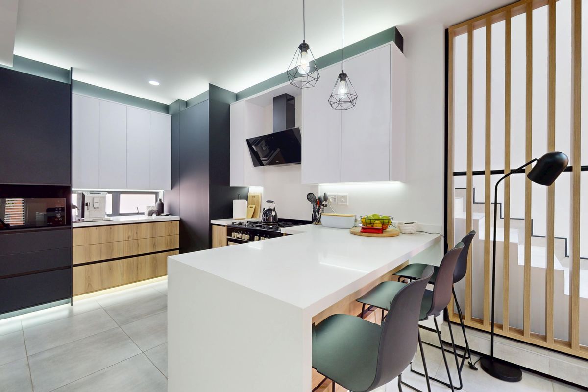 Modern kitchen featuring sleek two-tone cabinetry, stone countertops, a functional island, and integrated appliances with contemporary lighting and a timber slat feature screen.