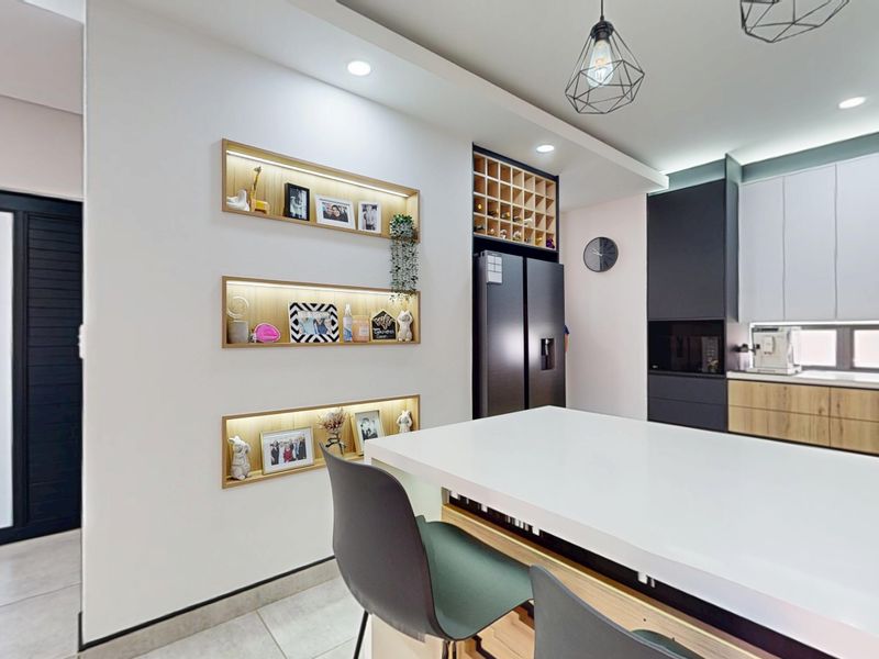 Modern kitchen featuring sleek two-tone cabinetry, a central island, integrated shelving with accent lighting, and contemporary pendant fixtures.