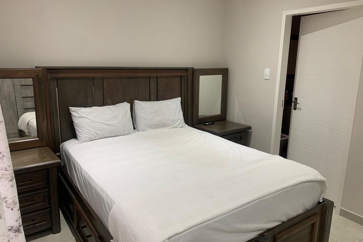 A well-maintained bedroom featuring neutral wall tones, tiled flooring, and a standard internal door leading to an adjacent space.