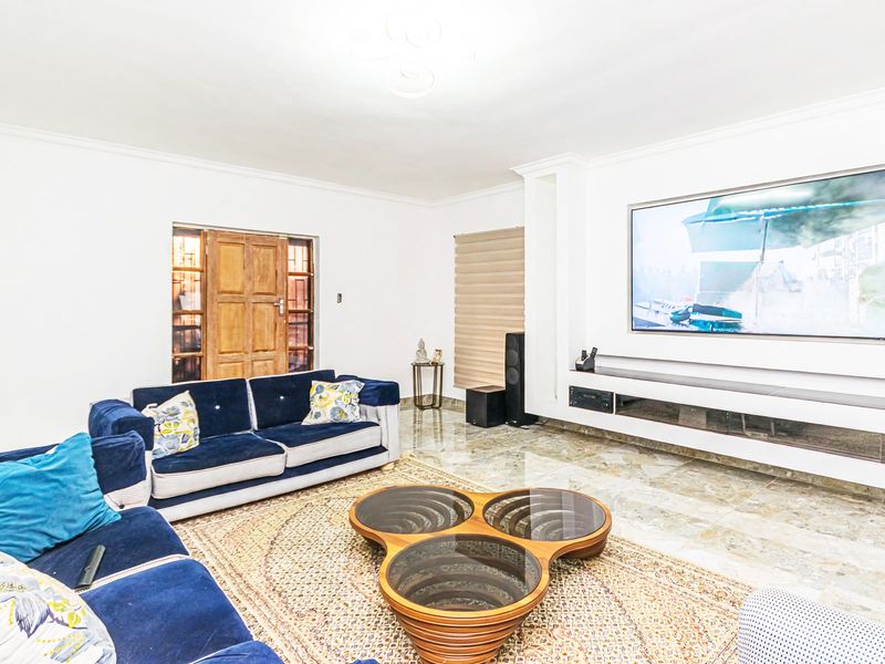 Spacious living room featuring polished marble flooring, a built-in media console with recessed wall niche, and neutral finishes.