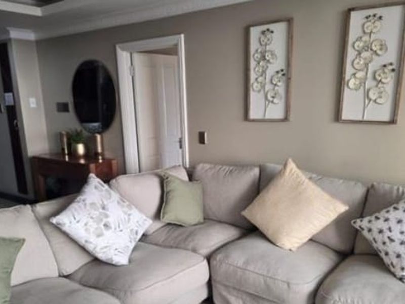 A comfortable living room featuring neutral wall tones, decorative ceiling coving, and classic interior door architraves.