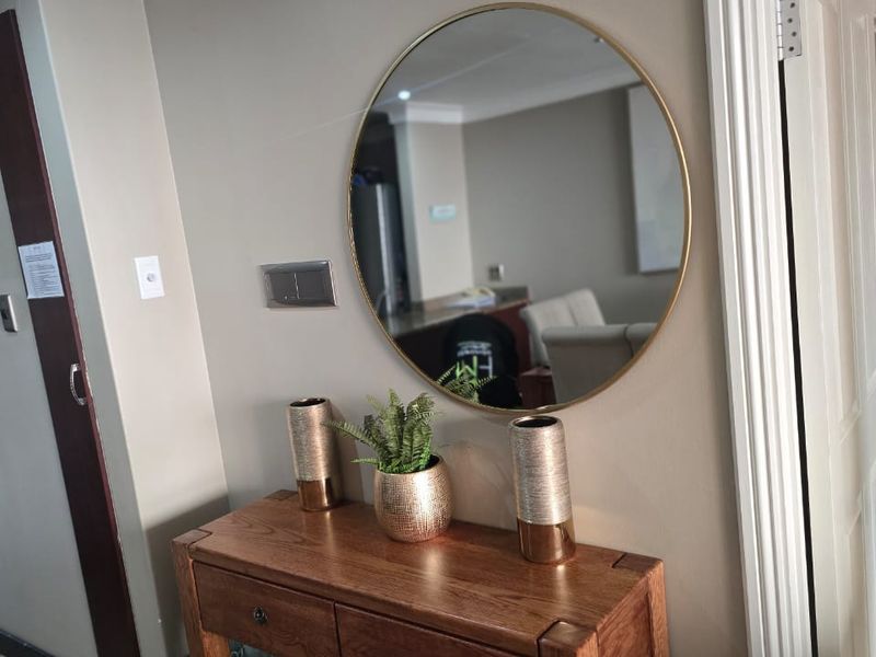 A well-maintained hallway featuring decorative crown molding, tiled flooring, and classic door architraves, providing a clean and welcoming transition between living spaces.